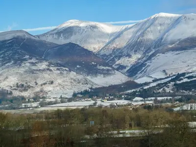 a mountain range with snow covered mountains in the background at Bracken Howe in Portinscale
