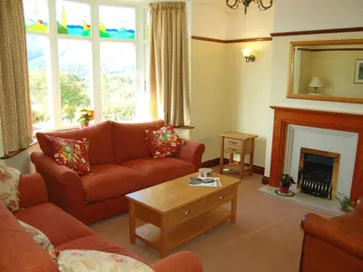 a living room with a couch and a fireplace at Bracken Howe in Portinscale