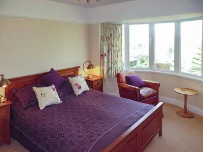 a bedroom with a purple bed and a chair at Bracken Howe in Portinscale
