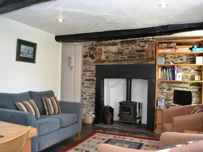 a living room with a couch and a fireplace at Blease Cottage in Threlkeld