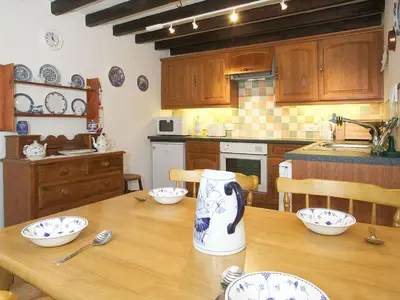 a kitchen with a wooden table with a vase on it at Cropple Howe in Threlkeld