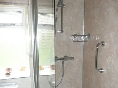 a shower with a glass door with a shower head at Cropple Howe in Threlkeld