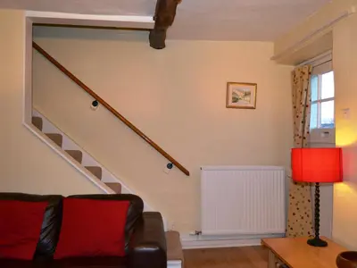 a living room with a staircase and a couch at Foxhole in Threlkeld