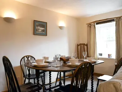 a dining room with a table and chairs and a window at Bridge House in Threlkeld