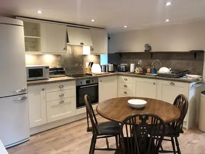 a kitchen with a wooden table and a table and chairs at Bridge House in Threlkeld