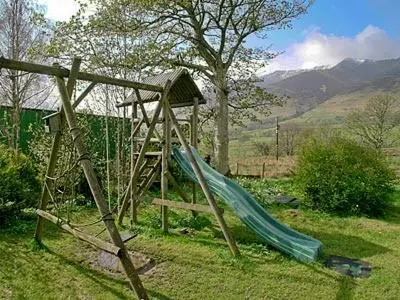a playground with a slide in the grass at Netherend in Threlkeld