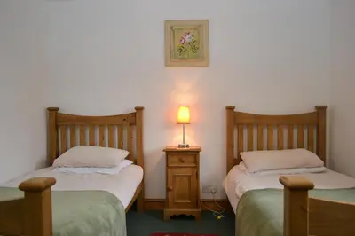 a bedroom with two beds and a lamp on a night stand at Netherend in Threlkeld