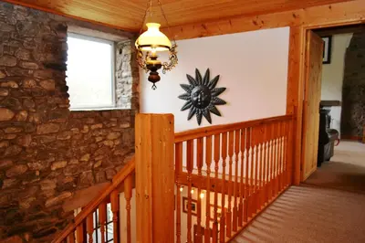 a staircase in a house with a clock on the wall at Netherend in Threlkeld