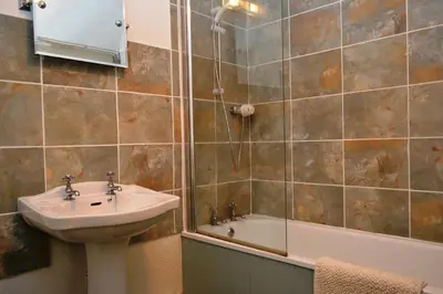 a bathroom with a sink and a shower and a tub at Netherend in Threlkeld