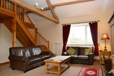 a living room with a leather couch and a table at Netherend in Threlkeld