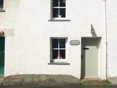 a white building with a window and a door at Lobstone Cottage in Rosthwaite