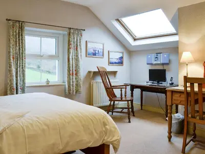 a bedroom with a bed and a desk with a computer at Brasscam in Rosthwaite