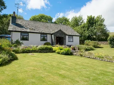 a small white house with a yard at Lookin How in Dockray