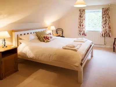 a bedroom with a large white bed and a window at Lookin How in Dockray