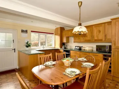 a kitchen with a wooden table and wooden cabinets at Molly's Cottage in Glenridding