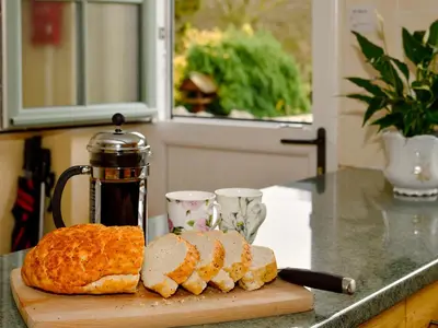 a loaf of bread on a cutting board on a counter at Molly's Cottage in Glenridding