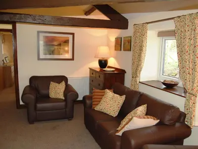 a living room with a couch and two chairs at Nuthatch Cottage in Westward