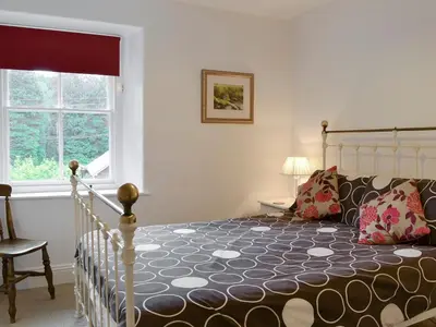 a bedroom with a large bed and a window at Roundhill Cottages 1 in Grasmere