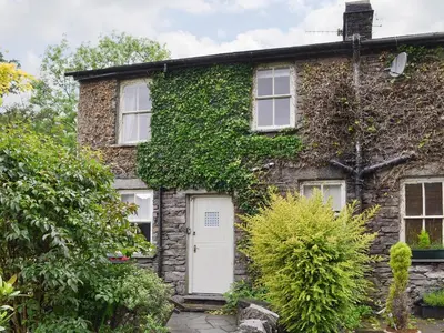 an ivy covered house with a white door at Roundhill Cottages 1 in Grasmere