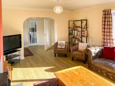 a living room with a couch and chairs and a tv at Fourwinds in Keswick