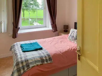 a bedroom with a bed and a window at Bonshawside Farmhouse in Kirtlebridge