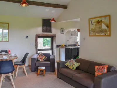 a living room with a couch and a table at Grooms Cottage in Plumbland