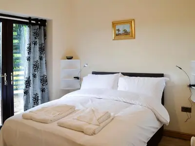 a bedroom with a white bed with towels on it at Grooms Cottage in Plumbland