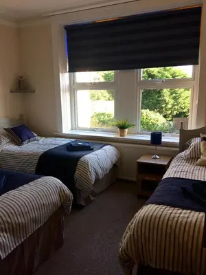 a bedroom with three beds and a window at Lismore Guest House in Whitehaven