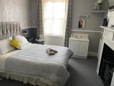 a bedroom with a large bed and a window at The Queens in St Bees
