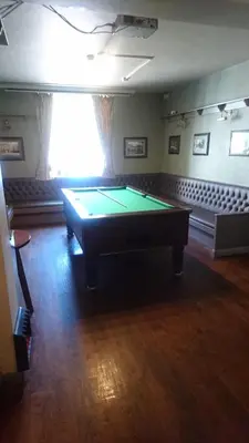 a room with a pool table in a room with at The Queens in St Bees