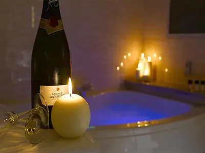 a bottle of champagne and a candle in a bathroom at The Sefton in Douglas