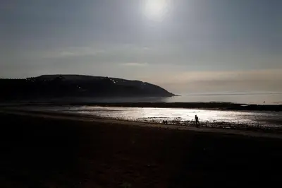 a person walking on a beach near the water at Best Western Palace Hotel & Casino in Douglas