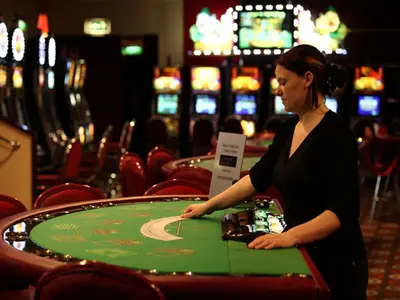 a woman standing at a table in a casino at Best Western Palace Hotel & Casino in Douglas