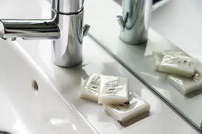 a bathroom counter with a mirror and some complimentary soap at The Lodge In The Vale in Thirlmere