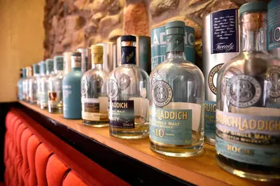 a row of bottles of alcohol on a shelf at The Farmers Inn in Dumfries