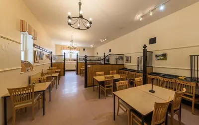 a restaurant with tables and chairs in a room at Muncaster Castle Coachman's Quarters in Ravenglass