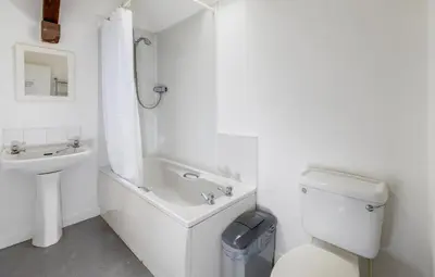 a white bathroom with a toilet and a sink at Muncaster Castle Coachman's Quarters in Ravenglass