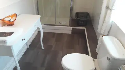 a bathroom with a toilet and a sink and a shower at Blueberry Two Bedroom Suite for 1, 2 or 3 people in Douglas