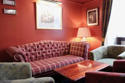 a living room with a couch and two chairs at Selkirk Arms Hotel in Kirkcudbright