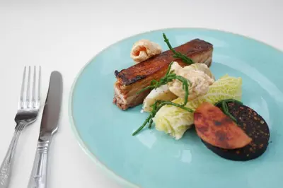a blue plate of food with meat and vegetables at Selkirk Arms Hotel in Kirkcudbright