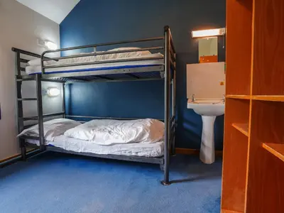 a bedroom with two bunk beds and a sink at YHA Borrowdale in Rosthwaite