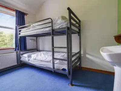 two bunk beds in a bathroom with a sink at YHA Borrowdale in Rosthwaite