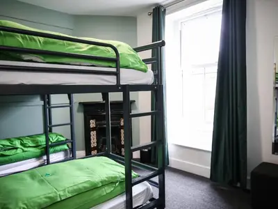 a room with three bunk beds and a window at YHA Keswick in Keswick