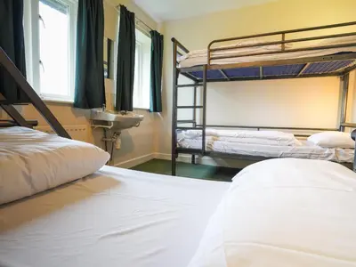 a bedroom with two bunk beds and a sink at YHA Eskdale in Eskdale
