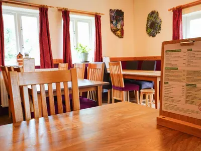 a dining room with tables and chairs and a sign at YHA Eskdale in Eskdale