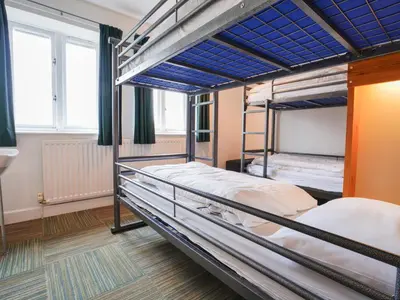 two bunk beds in a room with windows at YHA Eskdale in Eskdale