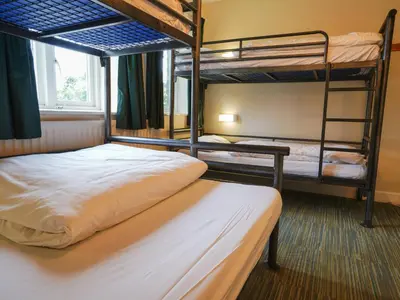 a bedroom with two bunk beds and a window at YHA Eskdale in Eskdale