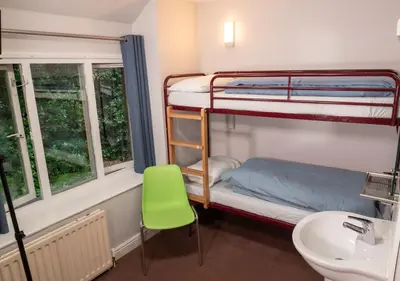 a bathroom with two bunk beds and a sink at YHA Grasmere Butharlyp Howe in Grasmere