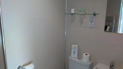 a white bathroom with a toilet and a sink at Swiss Court Guest House in Keswick