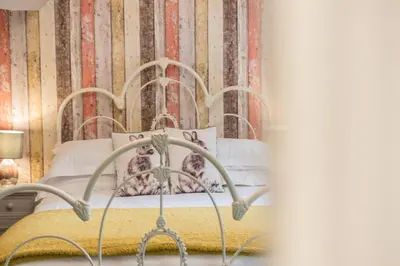 a bedroom with a metal bed with two pillows at Jacksons CafeBar & Guesthouse in Grasmere